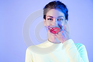Funny girl with full fake  lips on neon background.