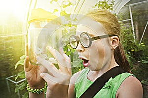 Funny girl with glasses and butterfly in a jar.