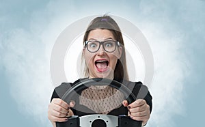 Funny girl in glasses with car wheel and white smoke, auto concept