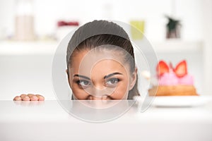 Funny girl hiding behind table.