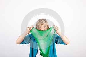 Funny girl holding green slime looks like gunk in front of her face