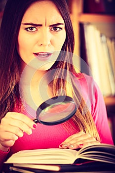Funny girl holding magnifying glass