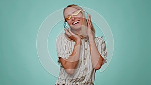 Funny girl listening music smiling dancing to disco party music rhythmically moving hands having fun