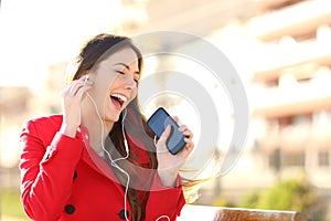 Funny girl listening to the music with earphones from a phone