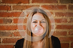 Funny girl making a pomp with a bubble gum