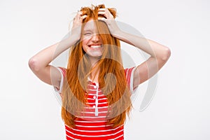 Funny girl with messy tousled hair holding hands to head