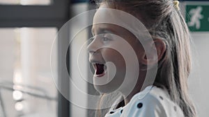 Funny girl playing air hockey. She smiles cheerfully.