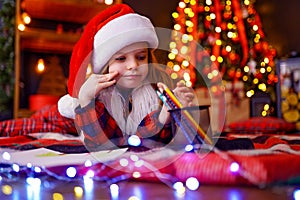 Funny girl in Santa hat writes letter to Santa