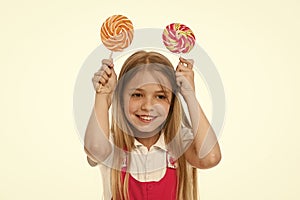 Funny girl smiling with swirl caramels. Little kid smile with candies on sticks isolated on white. Sweet and extremely