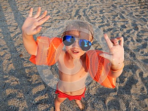 Funny girl in sunglasses on summer beach