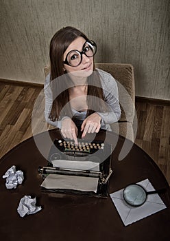 Funny girl typing on a typewriter