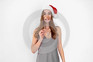 Funny girl wears Santa& x27;s hat wears pretend mustache isolated on white background New Year party