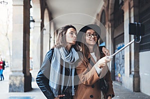 Funny girlfriends taking photo selfie on smartphone mobile. Blogger hipster travels in Barcelona. Holiday friendship kiss concept