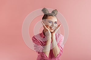 Funny girls with pigtails in pink shirt on pink background. Two bun hairstyle. Concept of naivety photo