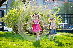 Funny girls walking on the lawn with her mother. Sisters play together with mom. maternal care. happy family