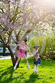 Funny girls walking on the lawn with her mother. Sisters play together with mom. maternal care. happy family