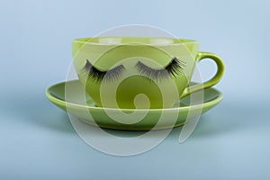 Funny green cup with eyes on a blue background