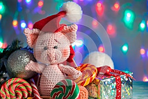 Funny greeting card with new year 2019. Pink pig with lollipops closeup on background with illumination