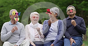 Funny, group and outdoor in the park with old people with costume, masks or photography with comedy. Silly, senior