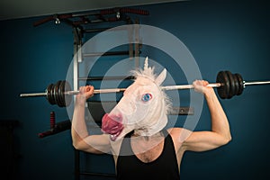 Funny guy in comical mask doing sport exercise