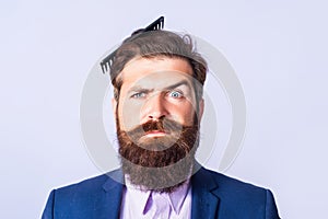 Funny hairstyle, modern haircut. Man styling his hair with a comb. Bearded man with beard, bearded gay.