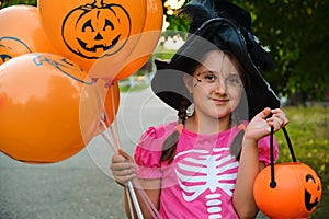 Funny Halloween kid in carnival costumes outdoors