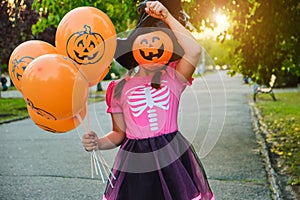 Funny Halloween kid in carnival costumes outdoors