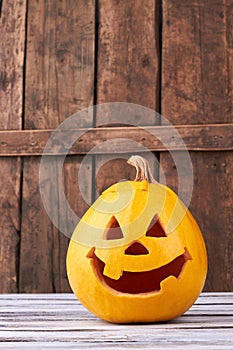 Funny Halloween pumpkin on wood background.