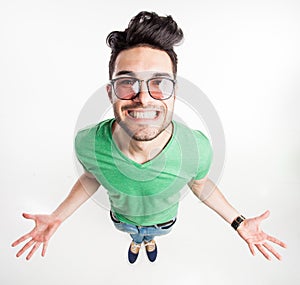 Funny handsome man with hipster glasses showing his palms and smiling large - wide angle shot