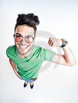 Funny handsome man with hipster glasses showing muscles - wide angle