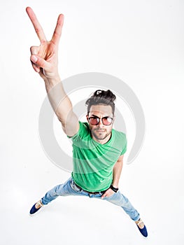 Funny handsome man with hipster glasses showing victory looking angry