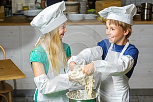 Funny happy chef boy width girl cooking at