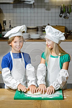 Funny happy chef boy width girl cooking at