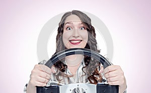 Funny happy emotions girl with car steering wheel, auto concept