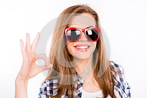 Funny happy girl in glasses showing gesture ok and smiling