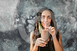 Funny happy woman drinking chocolate milk shake with cocoa and laughing