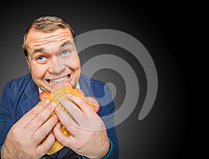 Funny hungry fat man eating the tasty sandwich