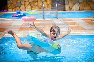 Funny image of little cute girl having funn in the outdoor pool at the resort. Summer holiday and happy carefree childhood concept