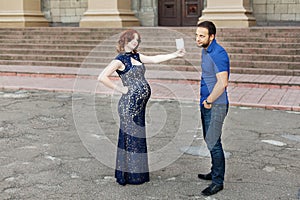 Funny image. Ð¡ouple expecting a baby: woman holds a sign