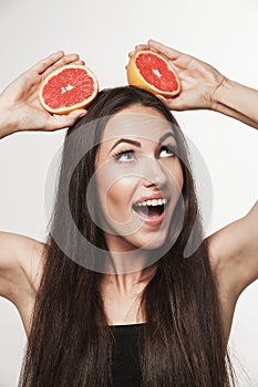 Funny image of young woman holding grapefruit