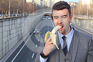 Funny inappropriate businessman biting a banana