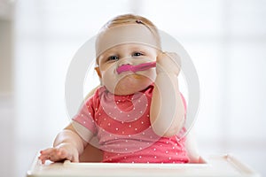 Funny infant baby spoon eats itself photo