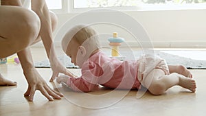 Funny infant crawling on floor from dad to mum and taking phone