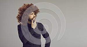 Funny intrigued man looking away at copy space standing on grey banner background
