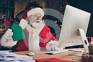 Funny jolly holly grey hair santa claus sit table work computer answer kids x-mas wish list letters hold envelope wear