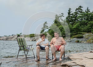 Funny joyful friends talking laughing relaxing in park near the lake