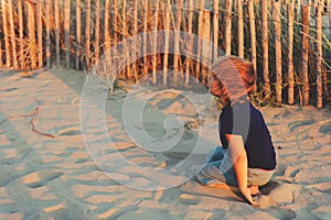 Funny kid boy resting on sand beach