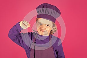 Funny kid chef cook with spoon. Kid chef cook, studio portrait. Children cooking. Kid boy with apron and chef hat.