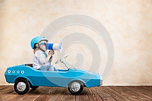 Funny kid driving toy car at home