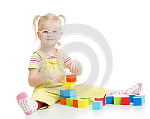 Funny kid in eyeglases playing building blocks photo